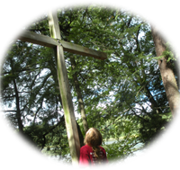 Small girl standing at the foot of the cross.